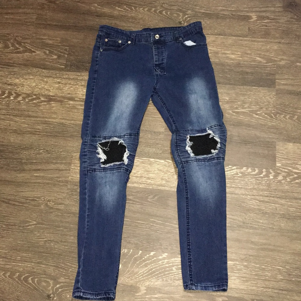 Dark blue jeans with black in the ripped holes